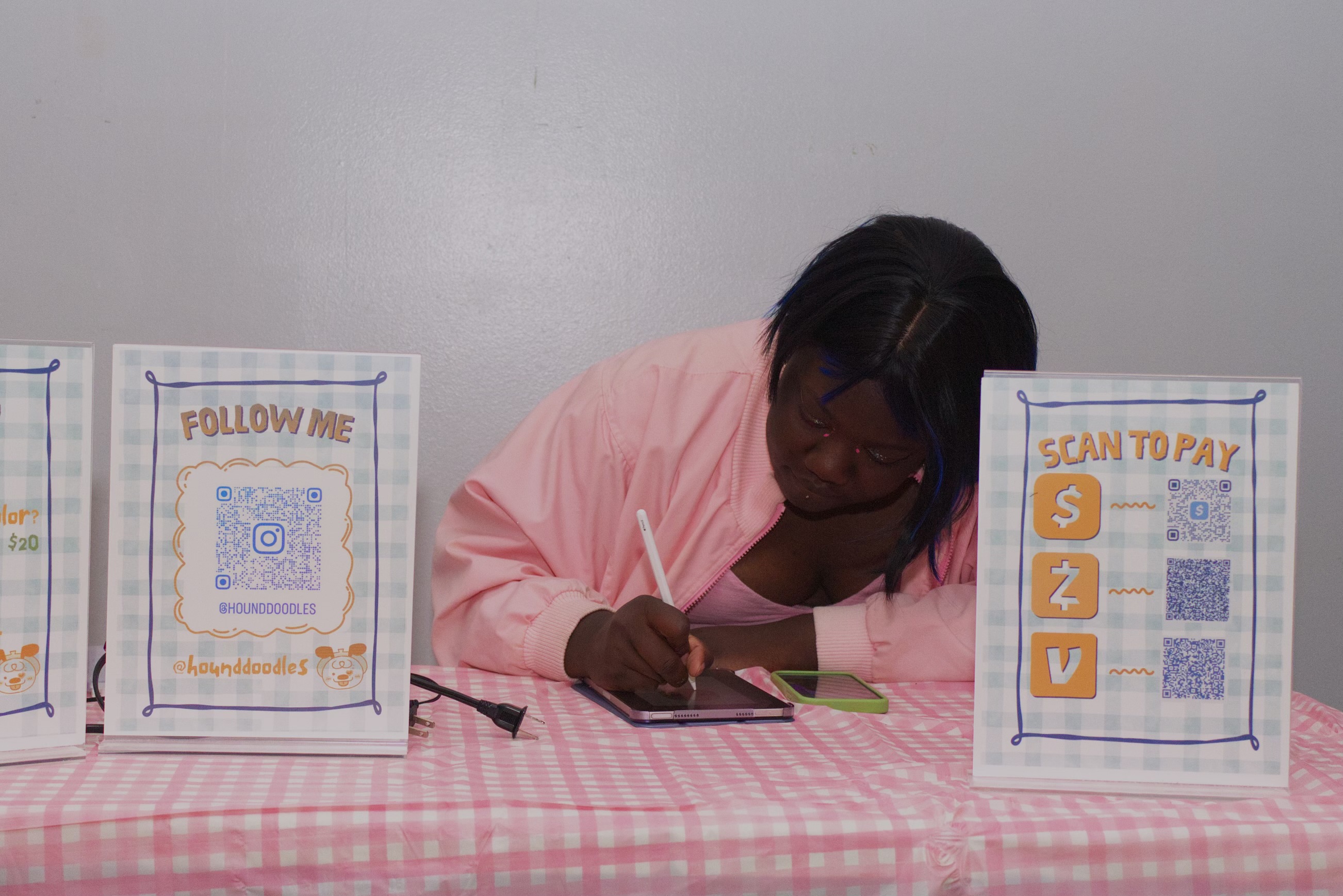 Ash drawing caricatures at a clothed table